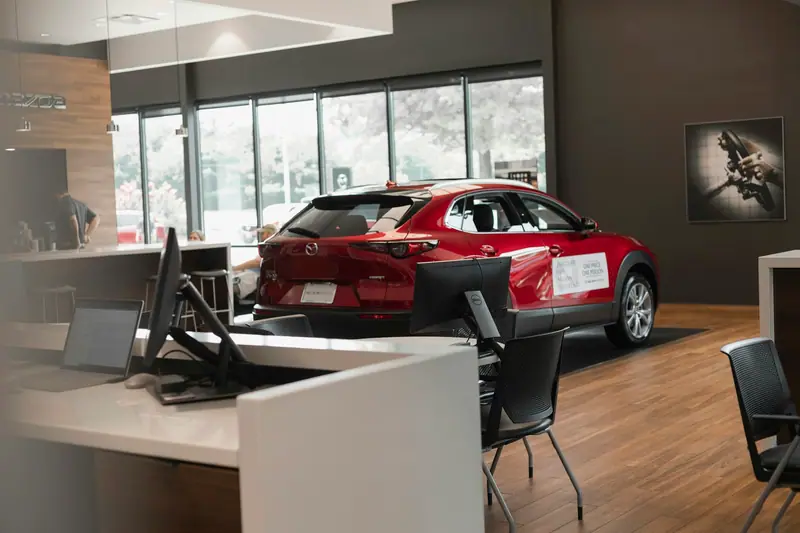 Bureau d’un showroom automobile avec une voiture rouge